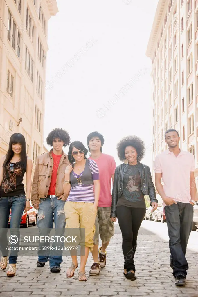 Multi-ethnic friends walking down urban sidewalk