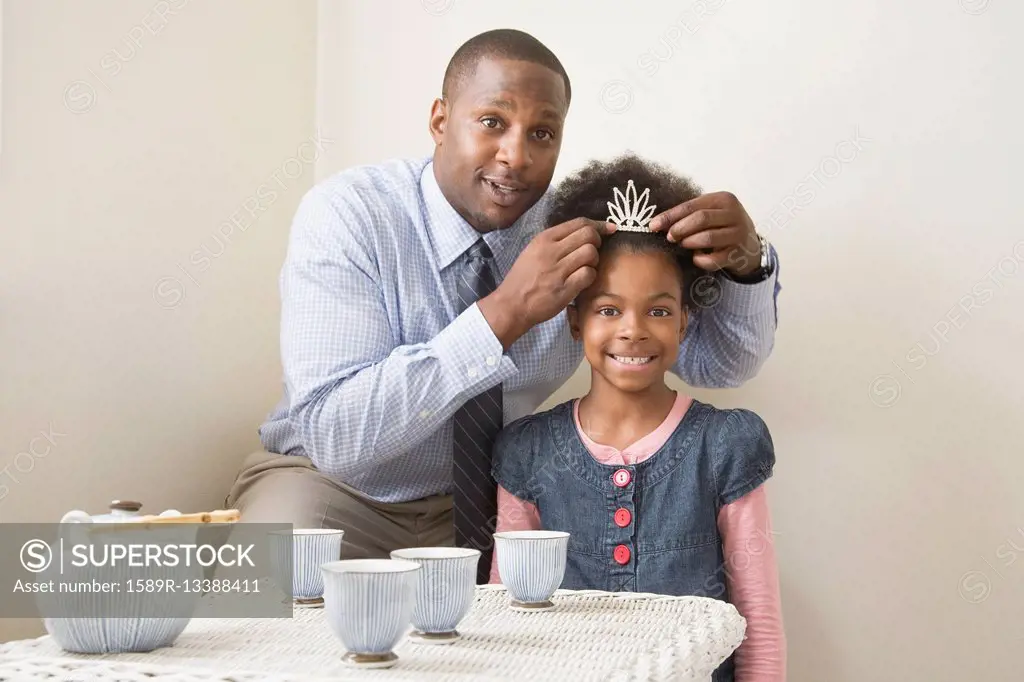 African father and daughter posing with tiara