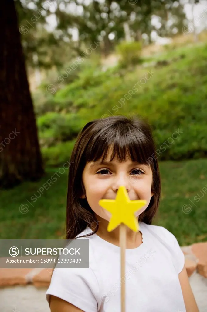 Mixed race girl holding star wand