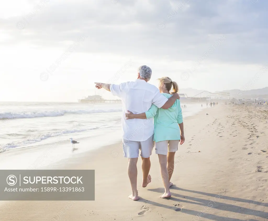 Caucasian couple walking on beach