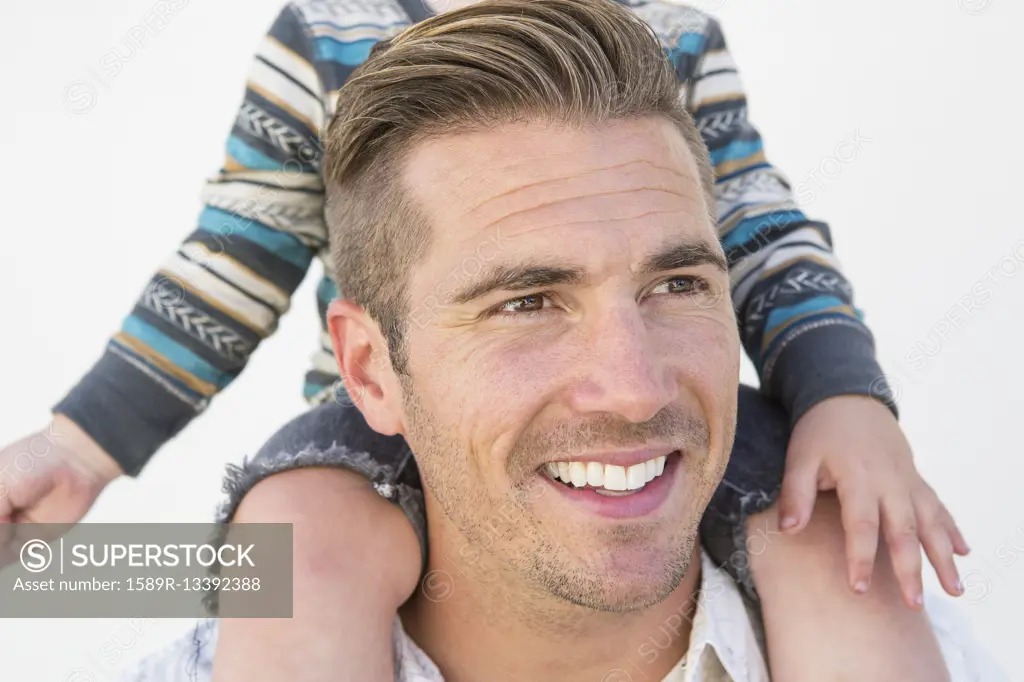 Close up of Caucasian father holding son on shoulders