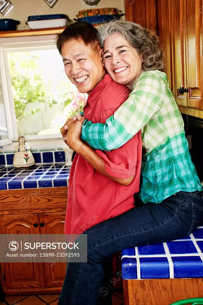 Smiling couple hugging in kitchen