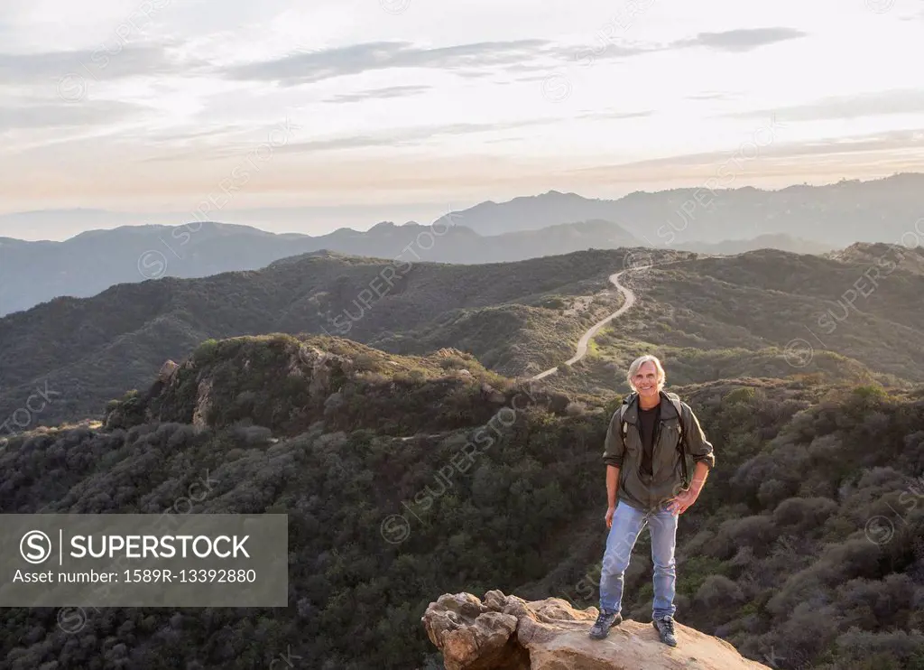 Older Caucasian man standing on rocky hilltop