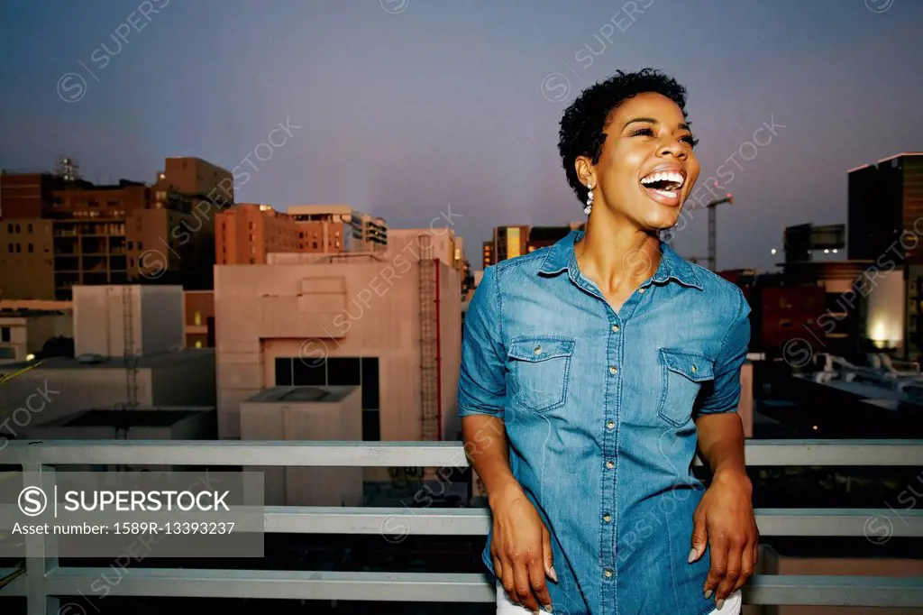 Woman laughing on urban rooftop