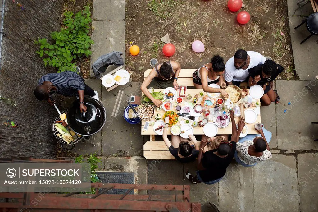 High angle view of friends enjoying backyard barbecue