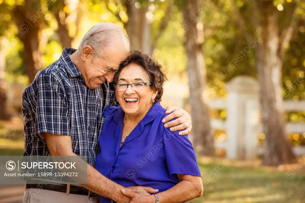 Older couple hugging in backyard