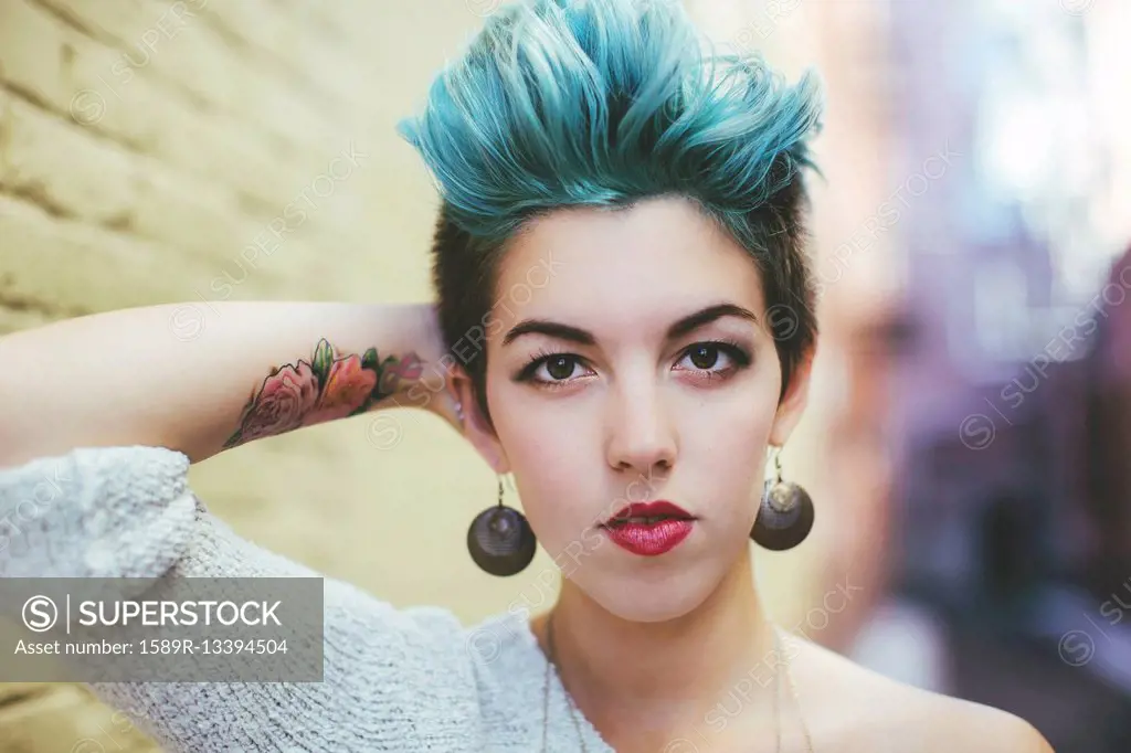 Stylish Caucasian woman with earrings and dyed hair