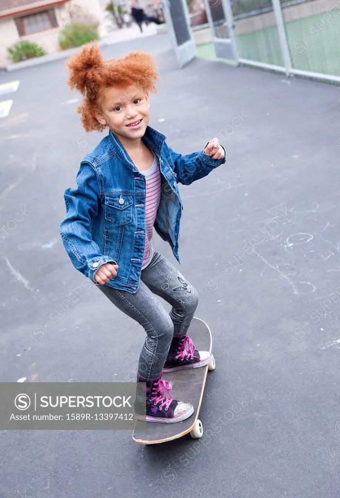 Girl riding skateboard in urban park