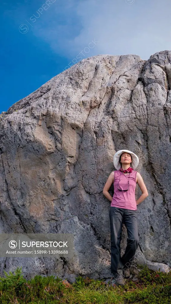 Japanese woman leaning on rock formation