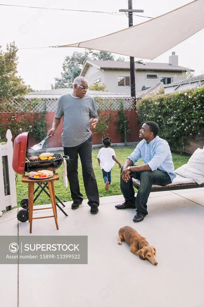 African American father and son talking at barbecue