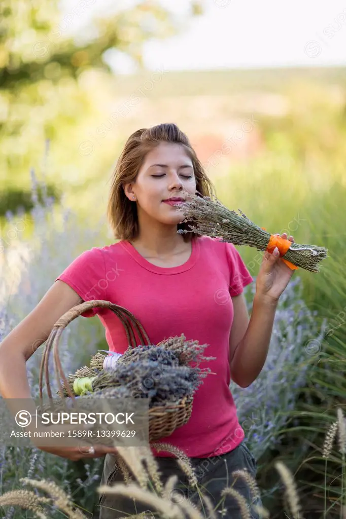 Mixed race woman smelling flowers in garden