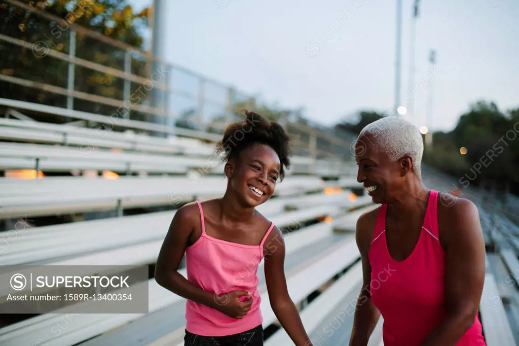 Grandmother and granddaughter standing on bleachers