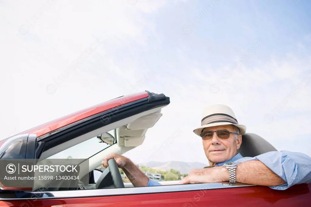 Older Caucasian man driving convertible