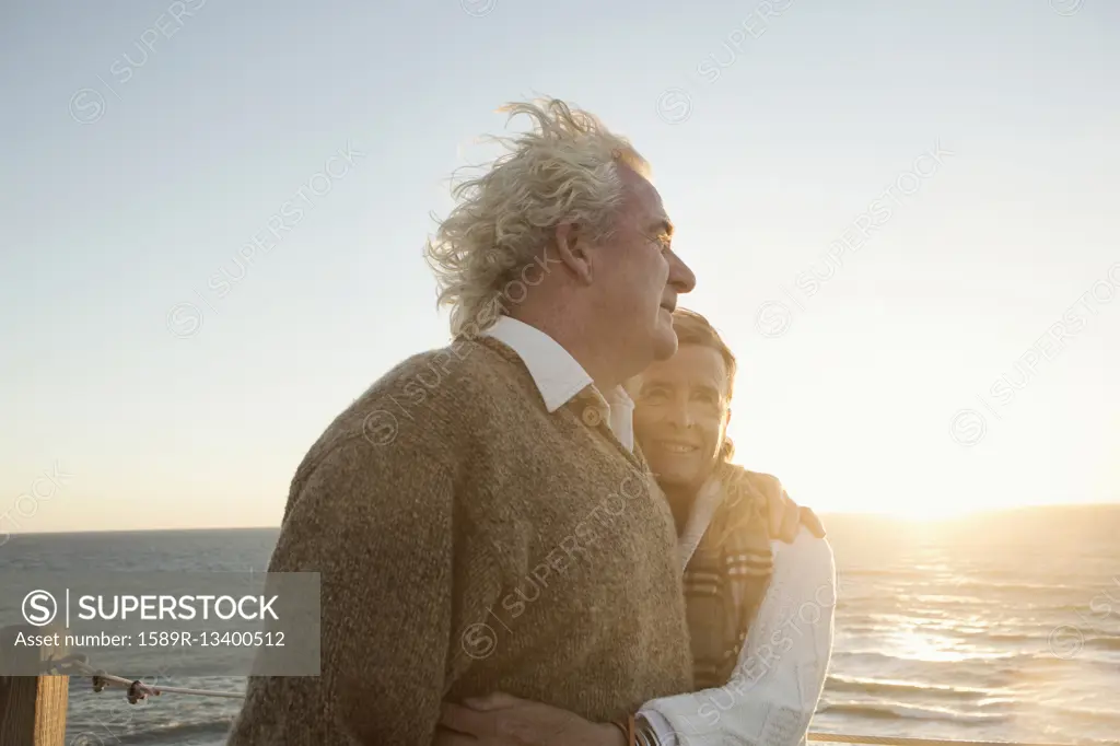 Older Caucasian couple hugging outdoors