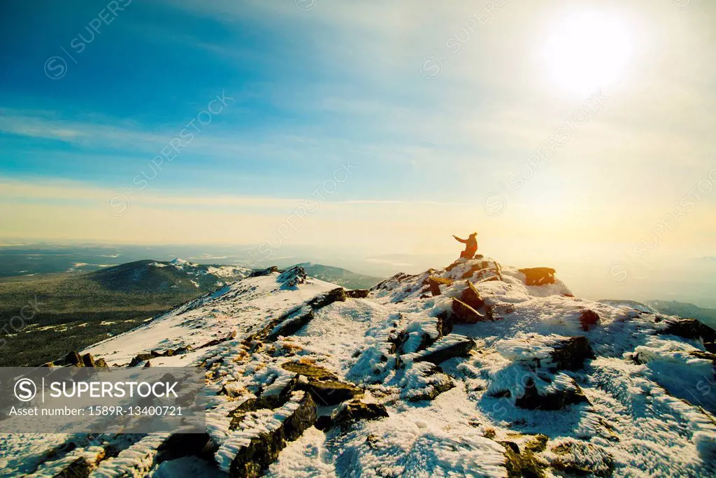 Woman sitting on mountain in winter