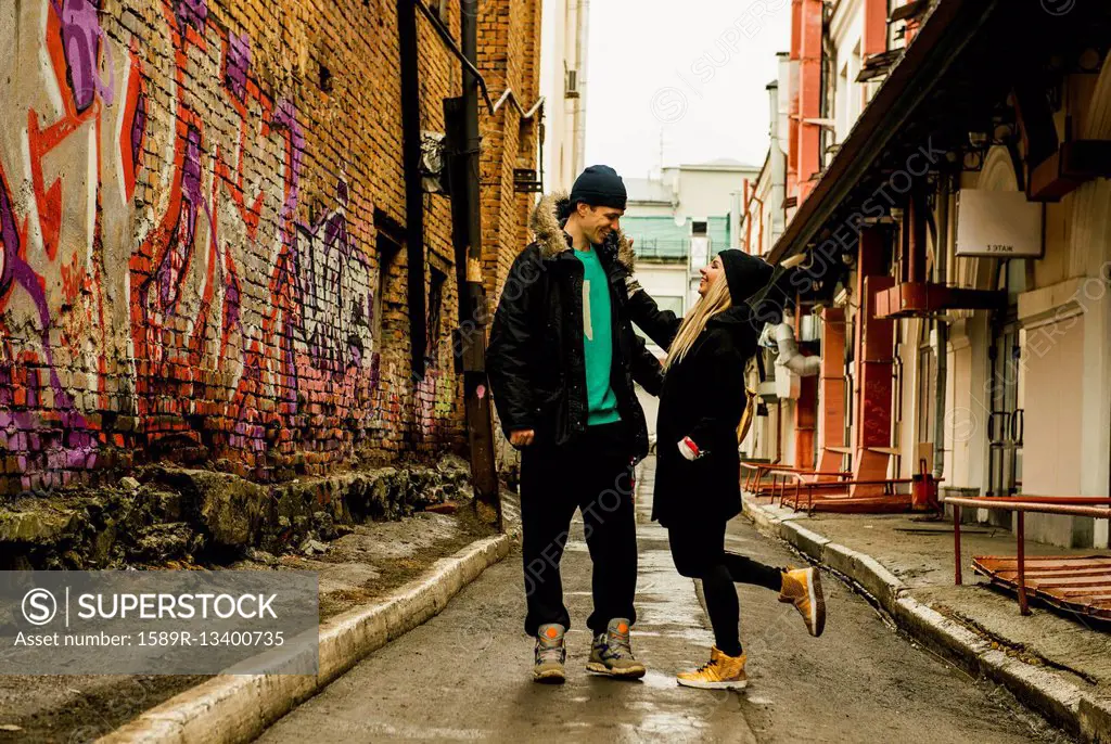 Playful couple in urban alley