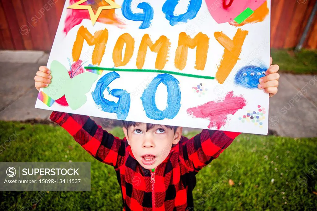 Mixed race boy holding Go mommy go sign