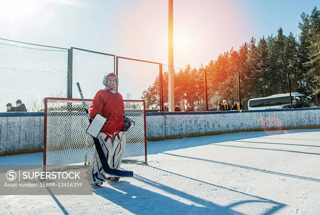 Caucasian boy playing goalie in ice hockey outdoors