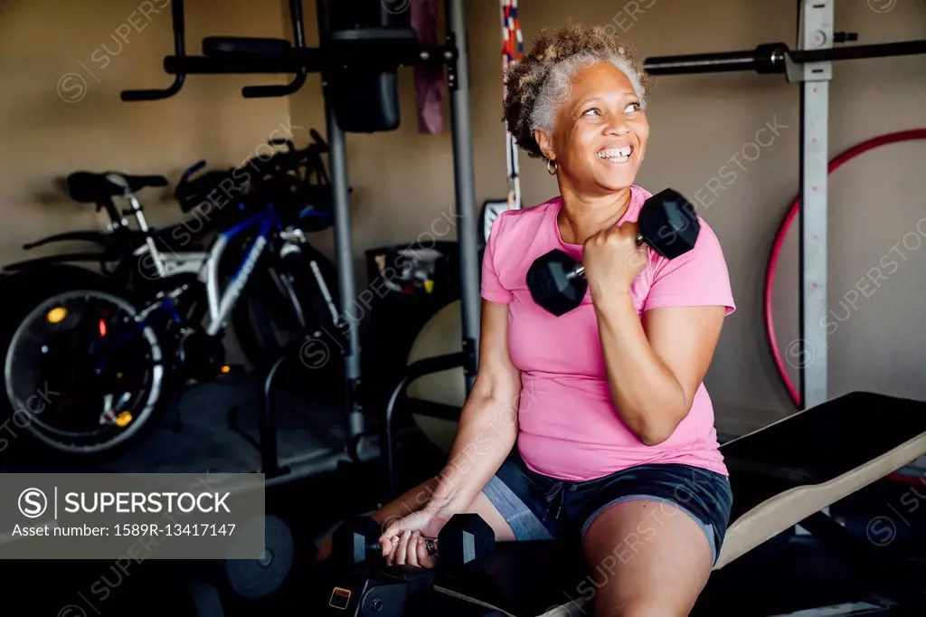 Black woman lifting weights in garage
