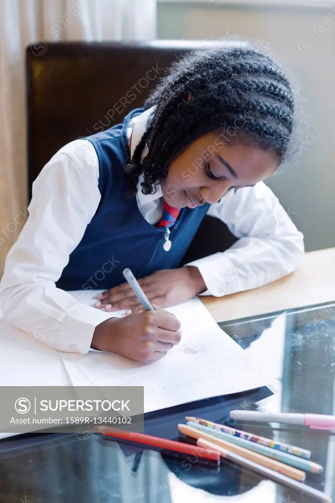 Black girl wearing school uniform doing homework