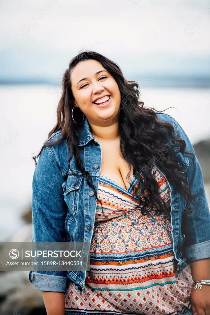 Smiling Mixed Race woman near ocean