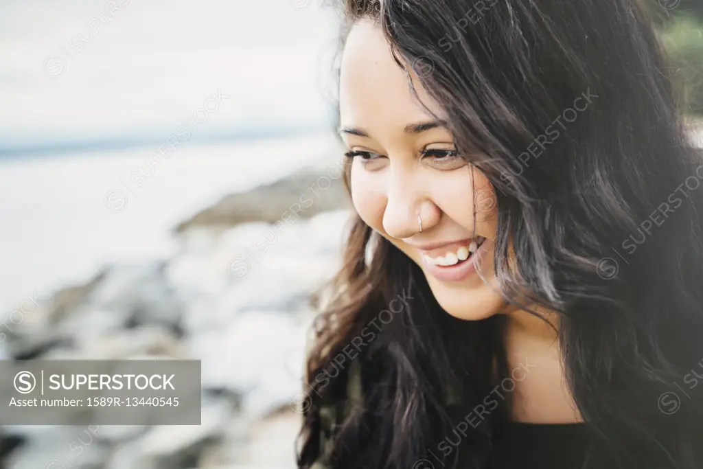 Smiling Mixed Race woman at ocean