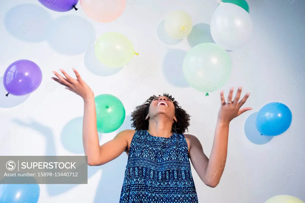 Black woman watching falling balloons