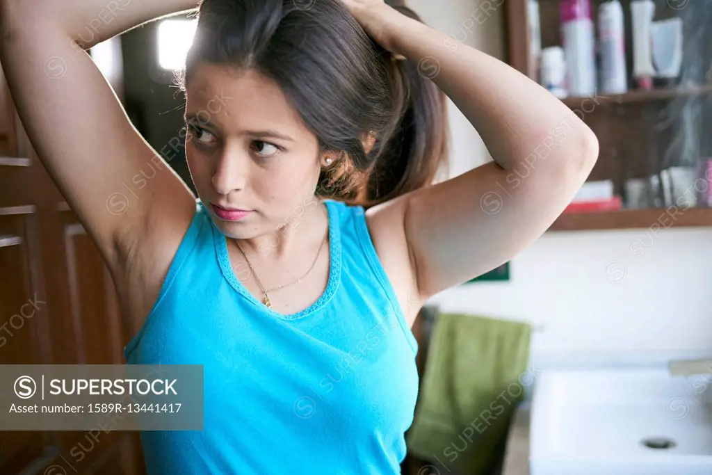 Hispanic woman lifting hair