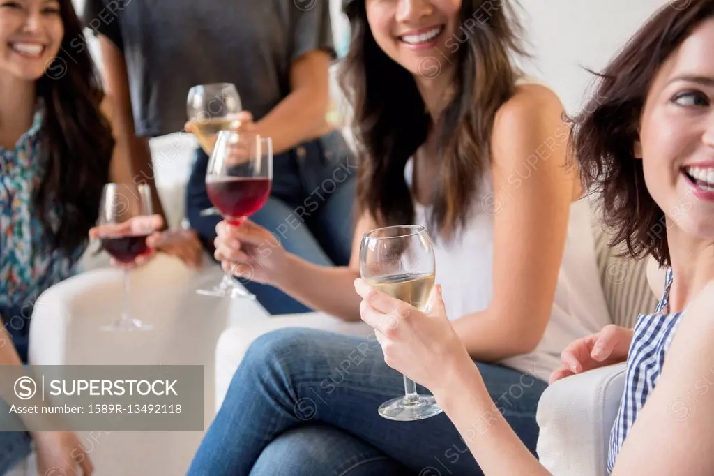 Smiling women drinking wine at party