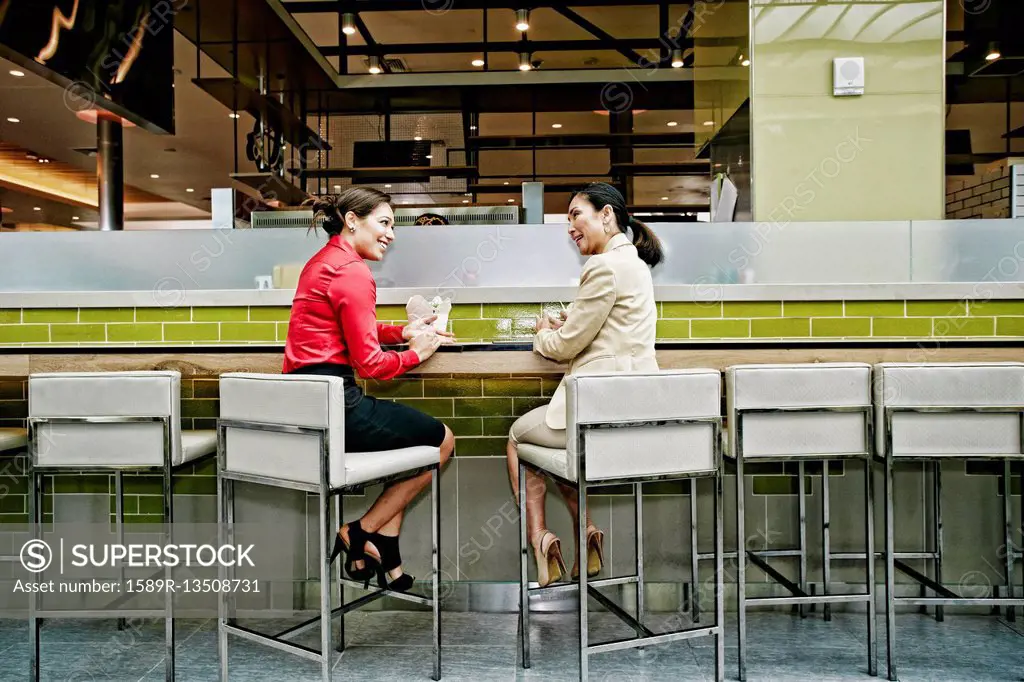 Smiling businesswomen talking in food court