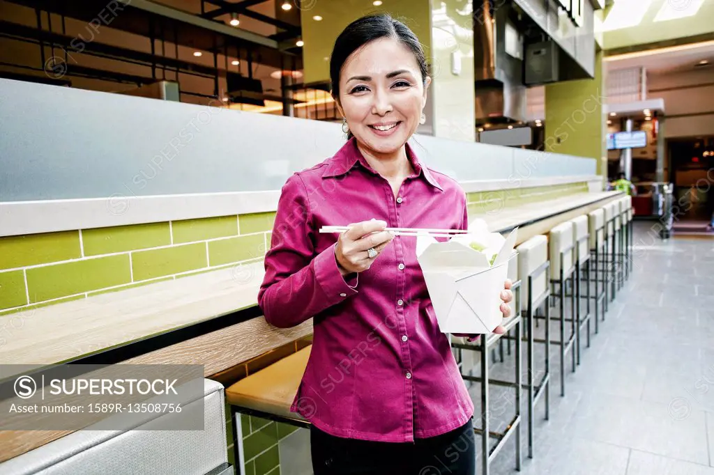 Smiling Japanese businesswoman posing in food court