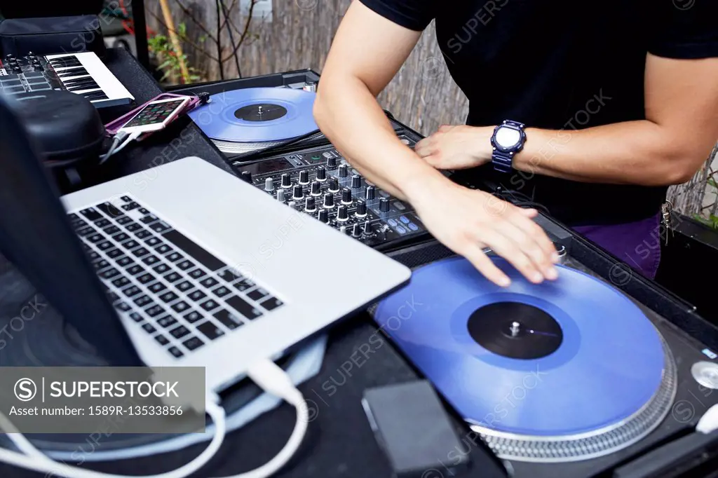 Hispanic dj playing music in backyard