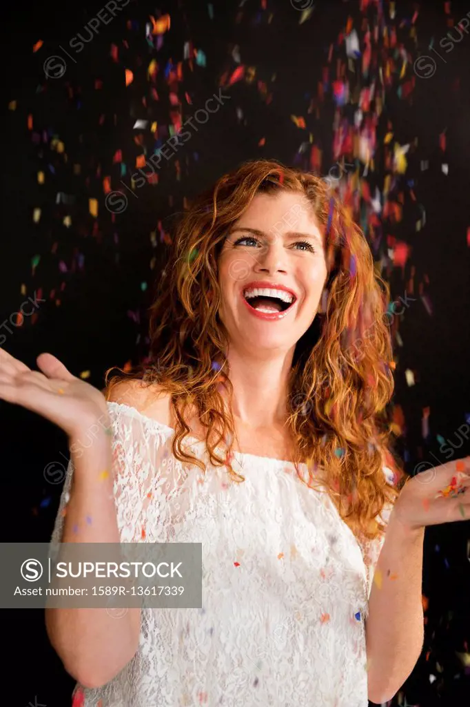 Confetti falling on celebrating Caucasian woman