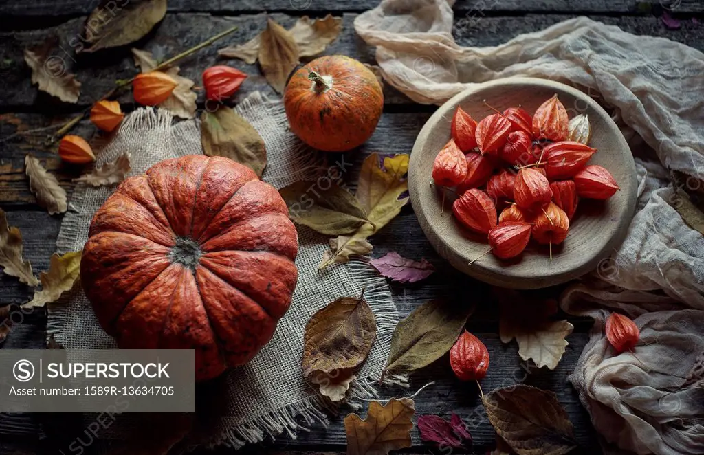 Pumpkins and autumn leaves on wooden table