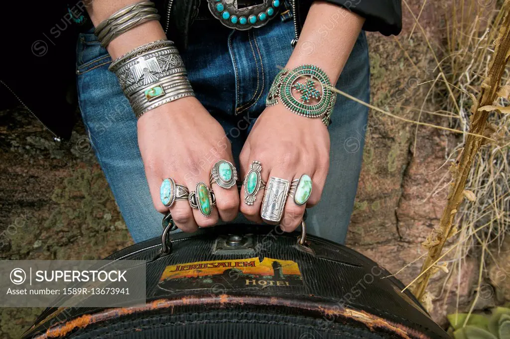 Arms and hands of Caucasian woman wearing ornate jewelry