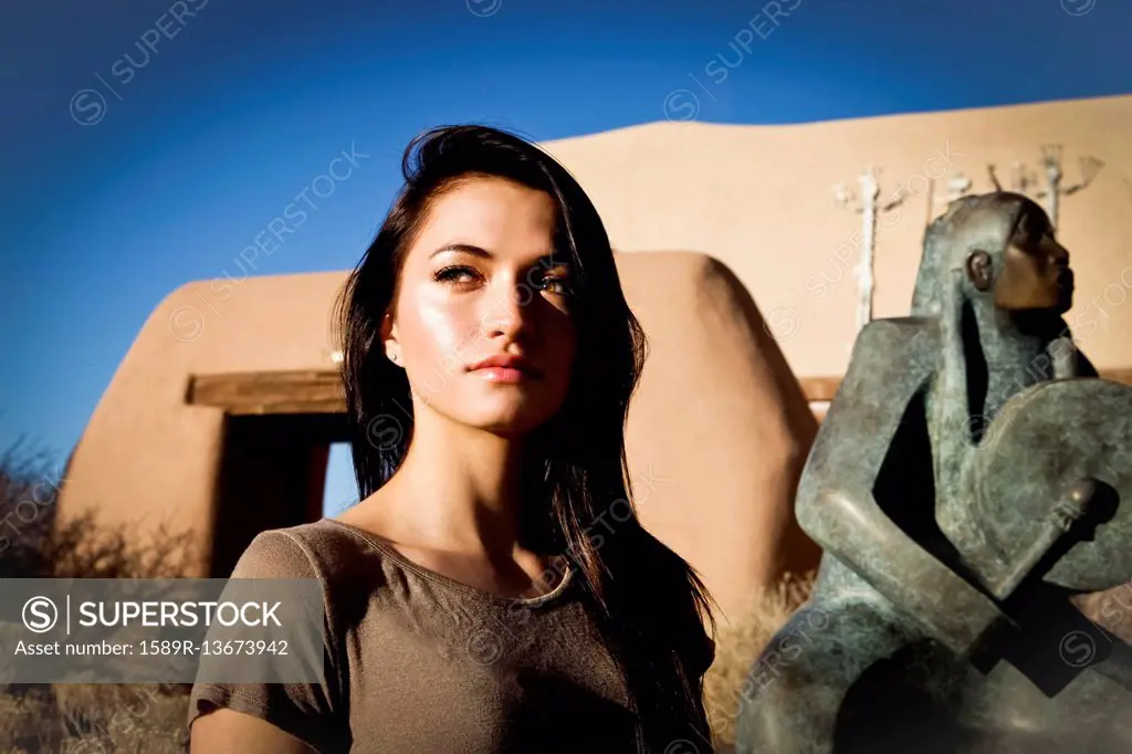 Portrait of Hispanic teenage girl near statue