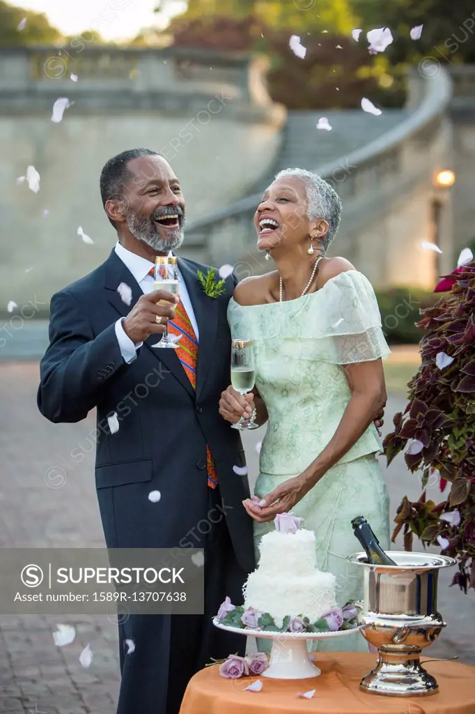 Flower petals falling on Black newlyweds