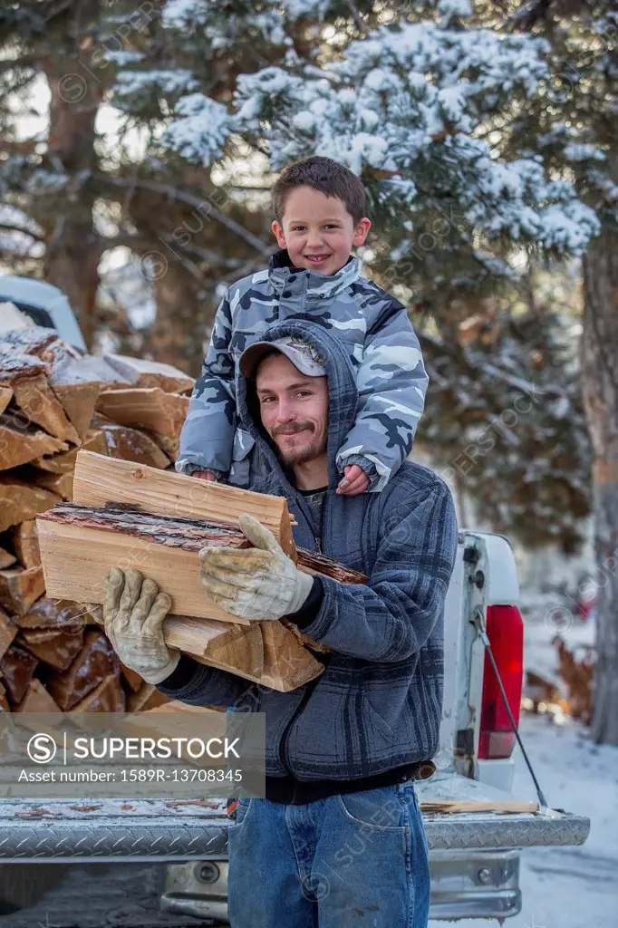 Caucasian father and son carrying firewood from truck