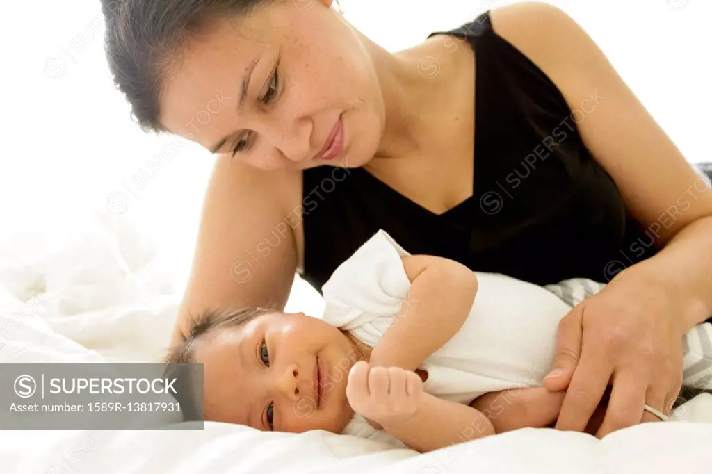 Mother laying on bed with baby son