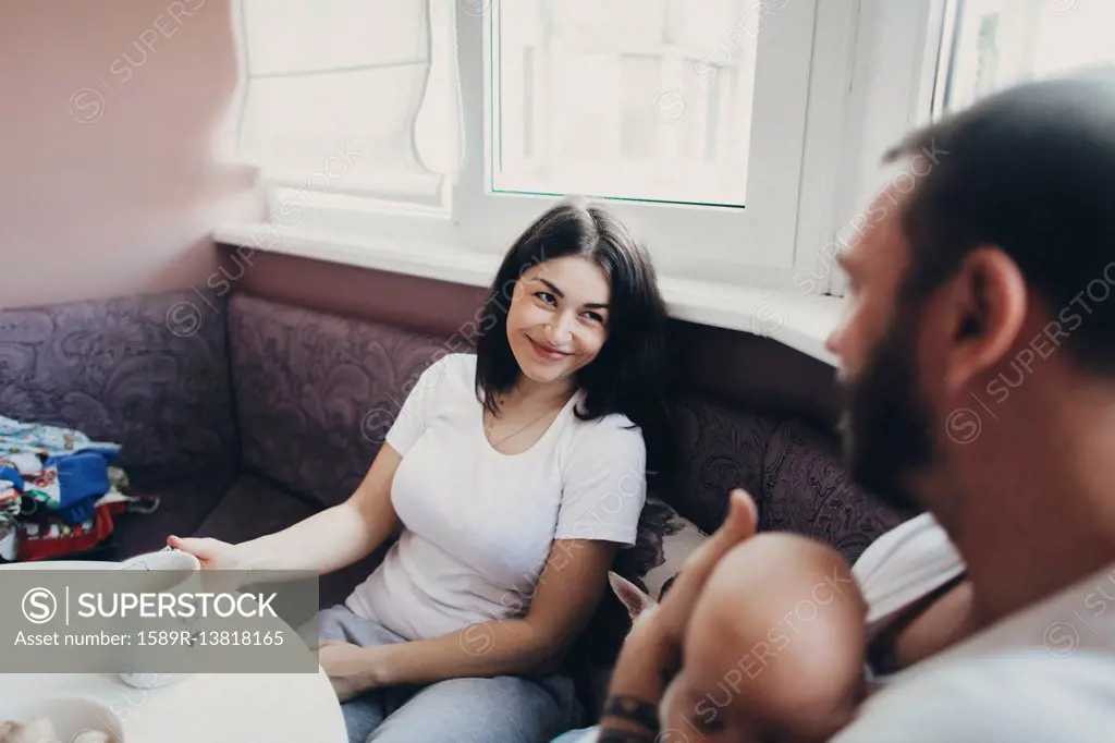 Caucasian mother and daughter sitting at table with baby son