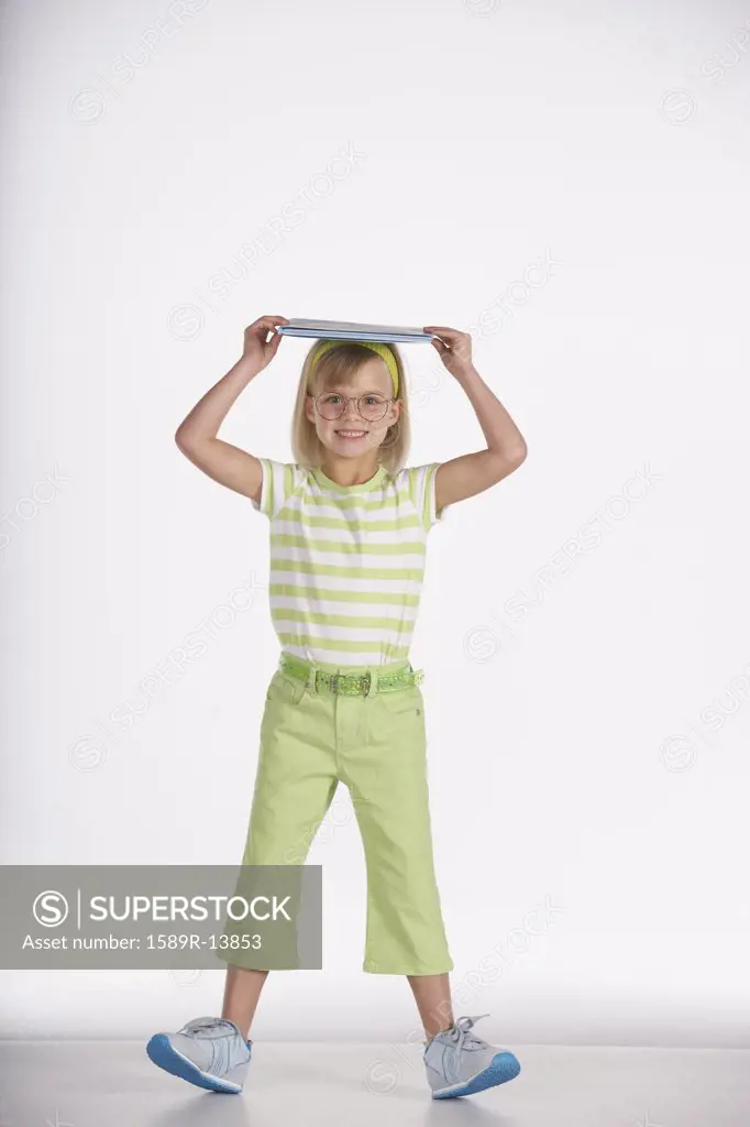 Portrait of girl balancing book in head