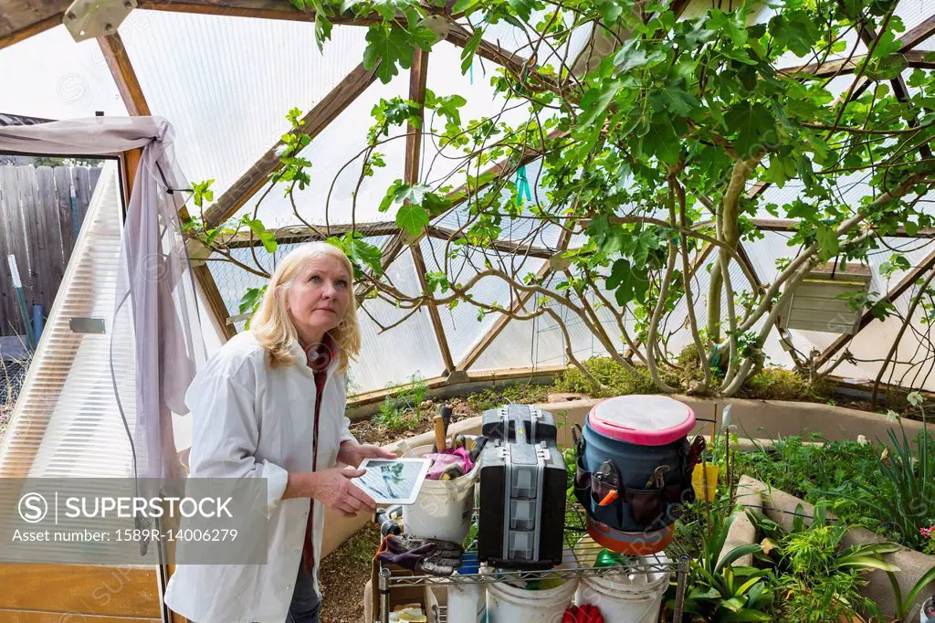 Caucasian scientist using digital tablet in greenhouse