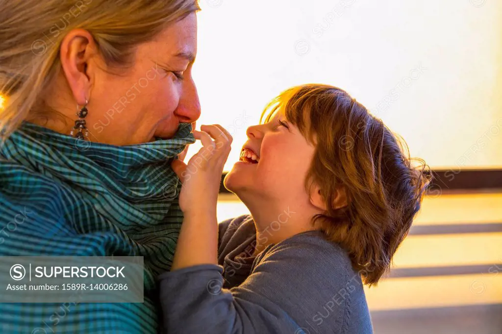 Caucasian mother watching son play with her collar