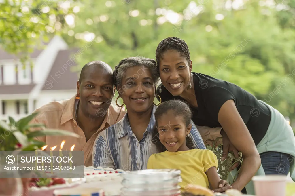 Portrait of smiling multi-generation family celebrating with cake