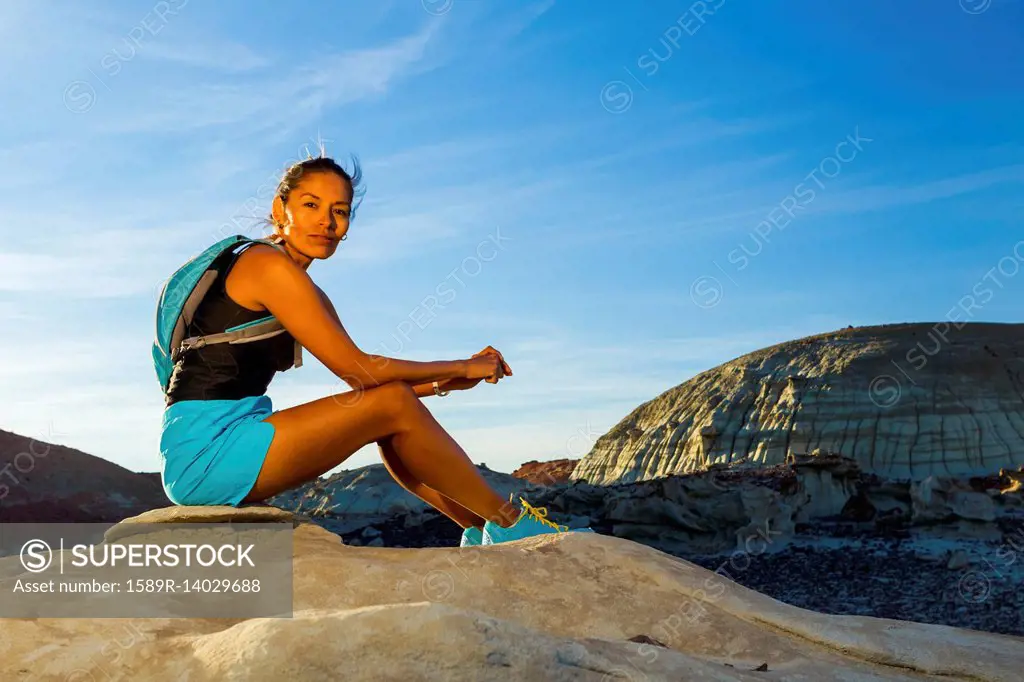 Native American woman sitting on rock in desert