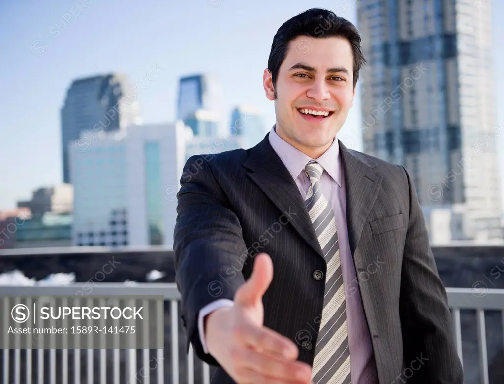 Hispanic businessman with hand outstretched