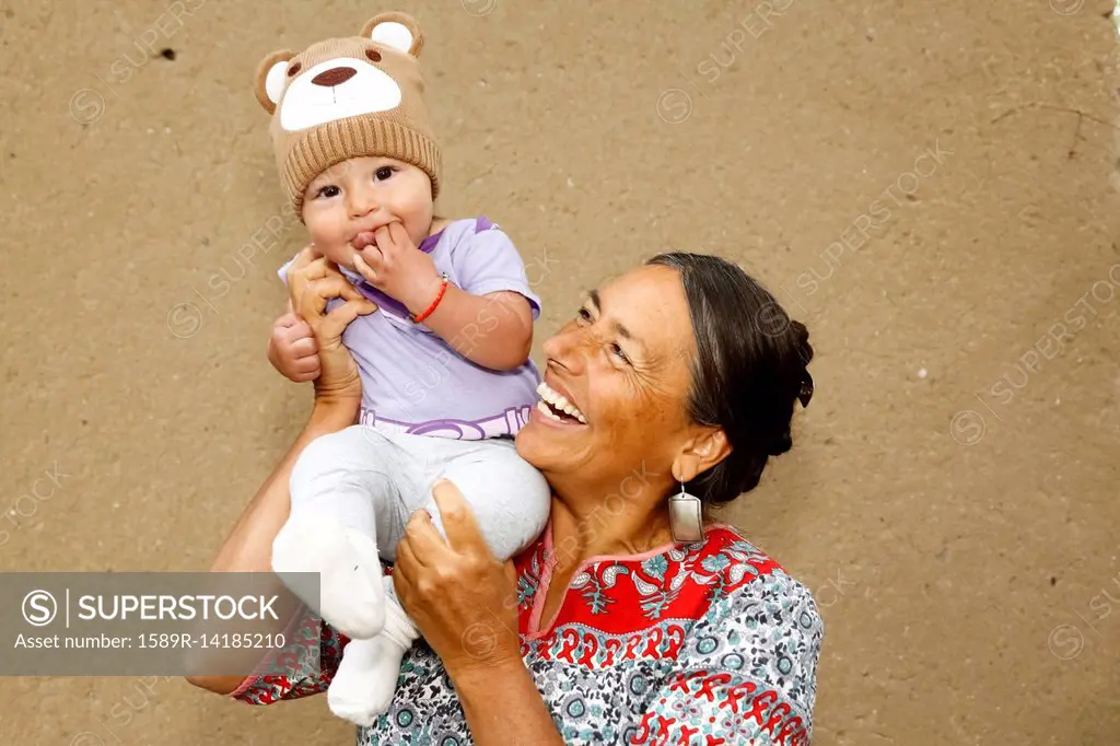 Mother carrying baby son on shoulder