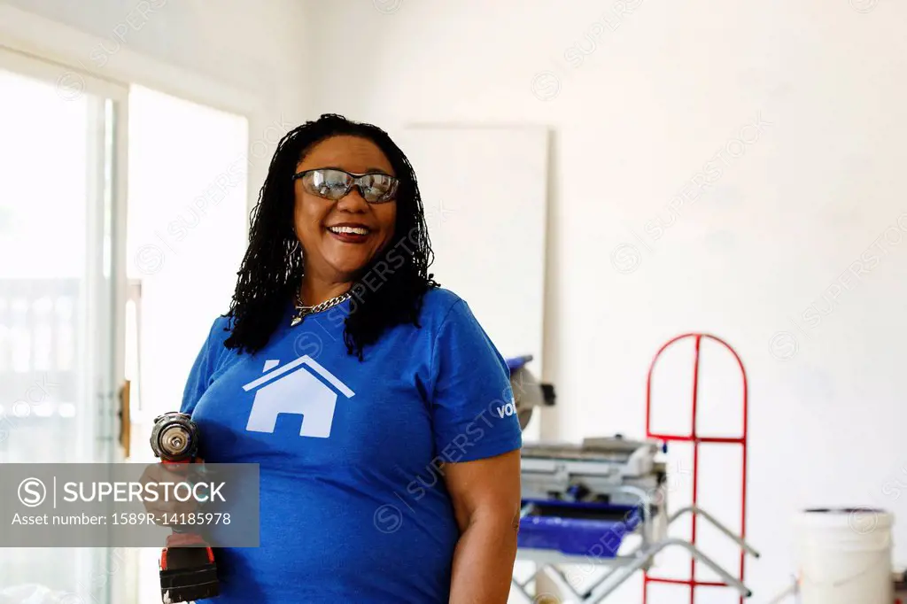 Black volunteer woman holding drill