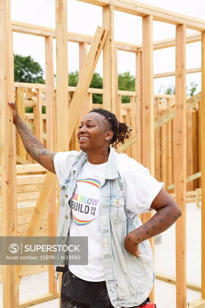 Mixed race man leaning on lumber at construction site