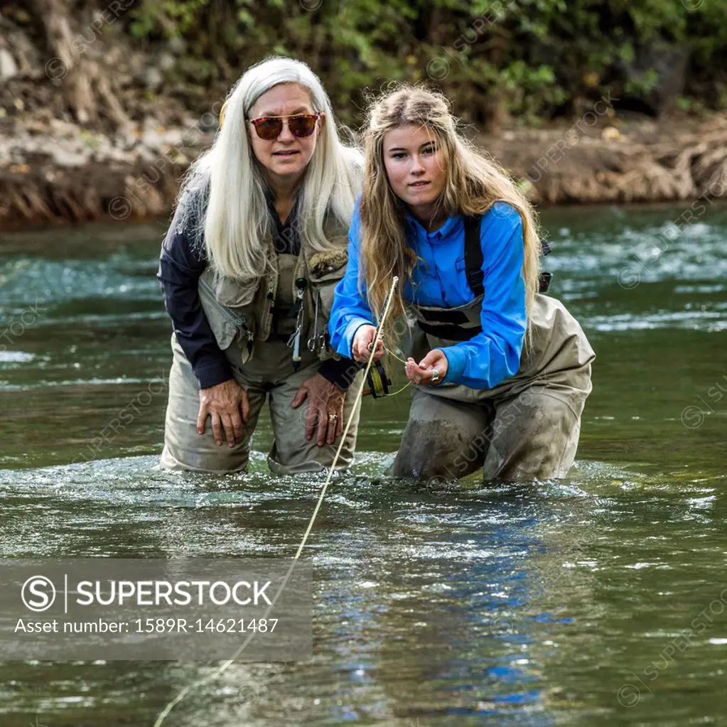 Caucasian mother and daughter fly fishing